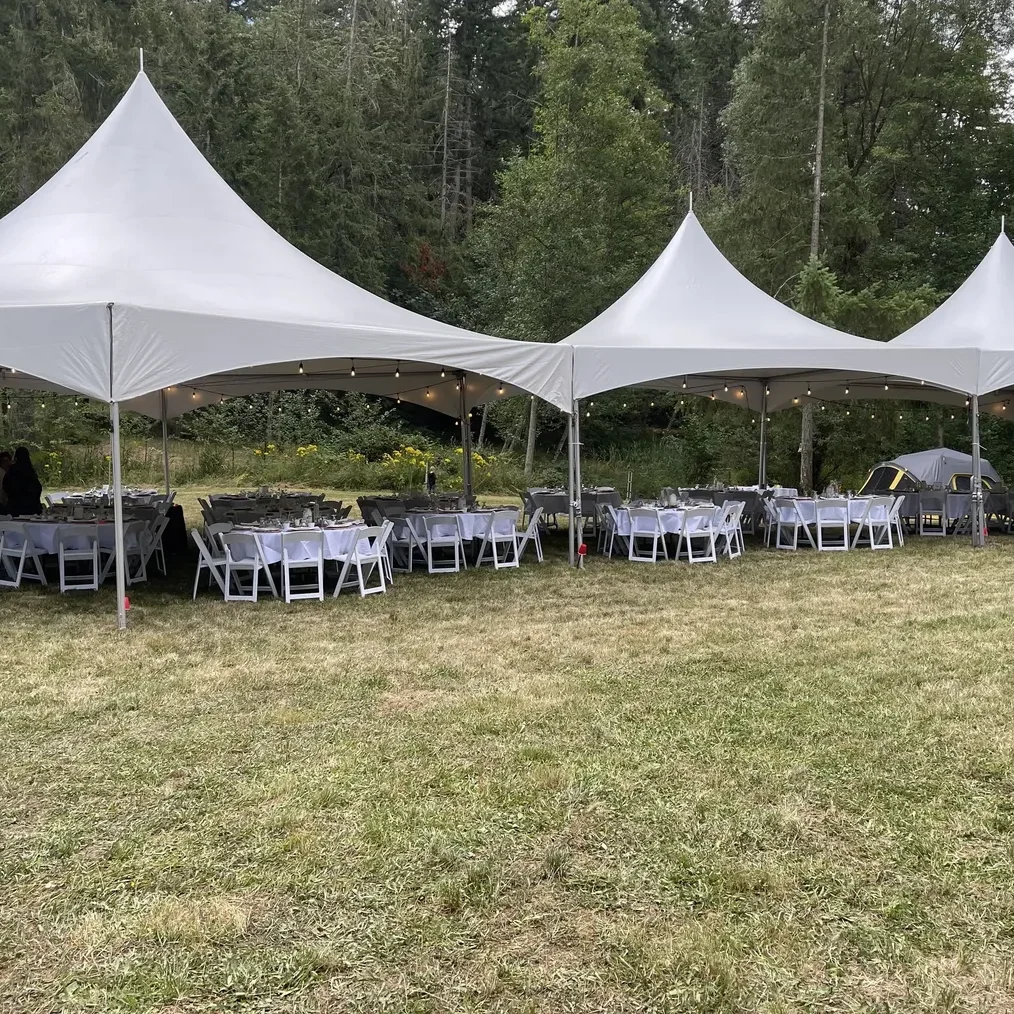 A group of tables and chairs in front of a tent.